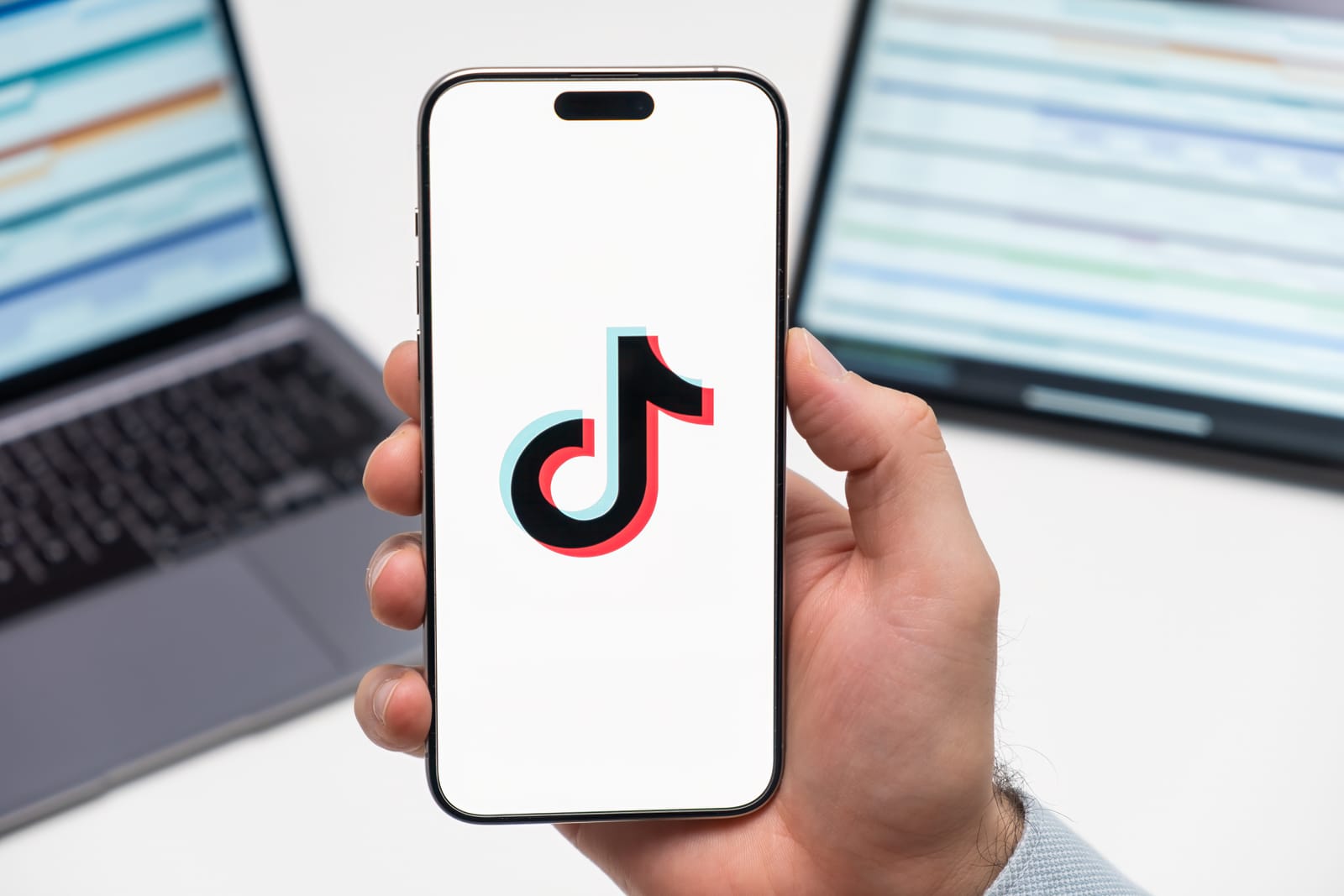 A person holding a smartphone displaying the TikTok logo, for an article about the launch of the new TikTok Notes app