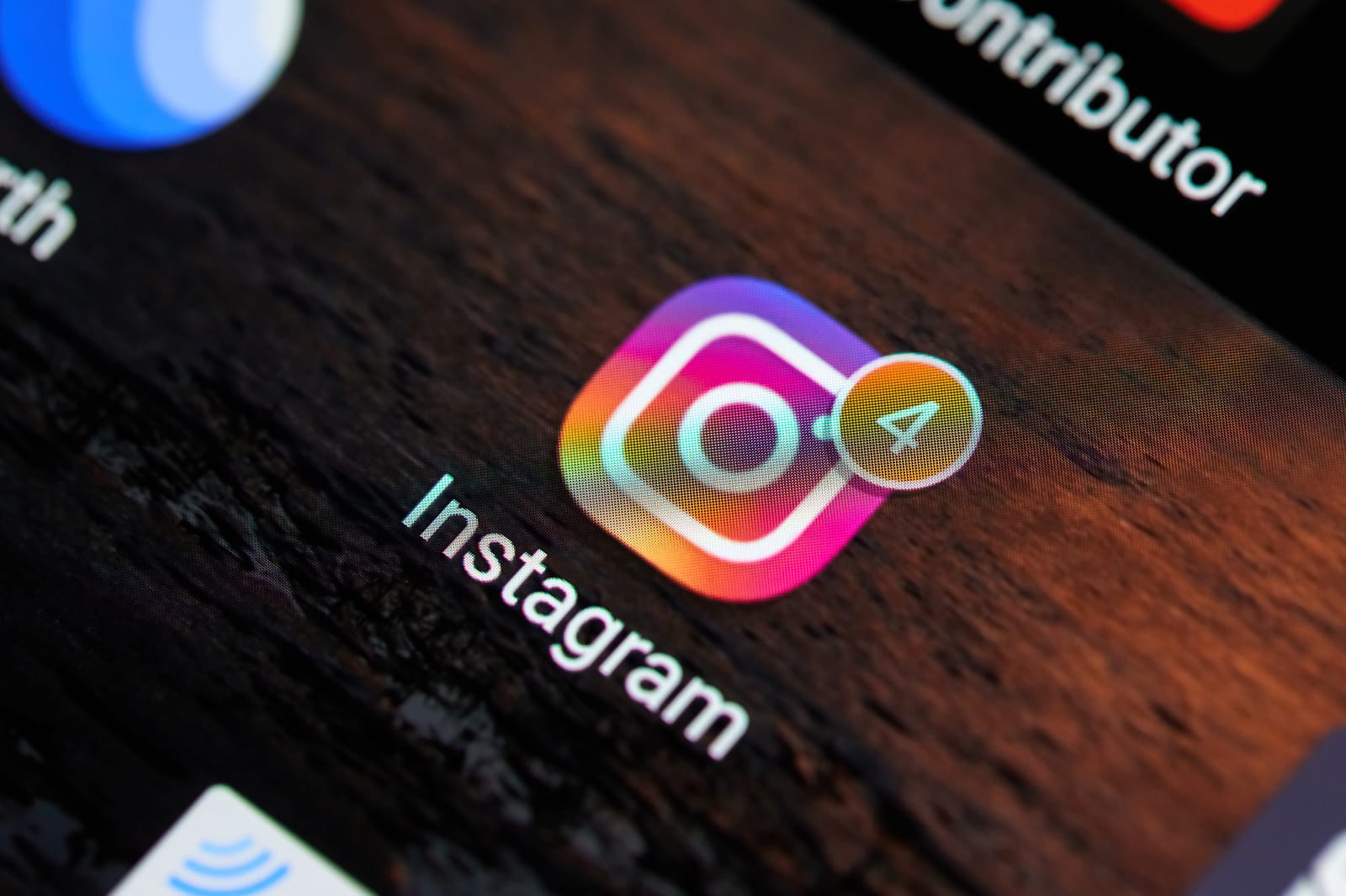A close-up macro photo of the Instagram app icon on a smartphone screen, showing a notification bubble.