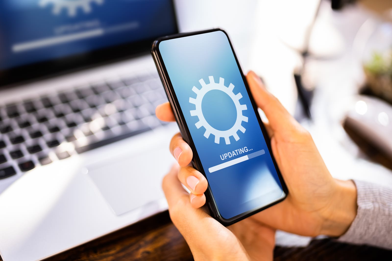 A person holding a phone showing a software update, illustrating the long-term support to consider if premium smartphones are worth it.