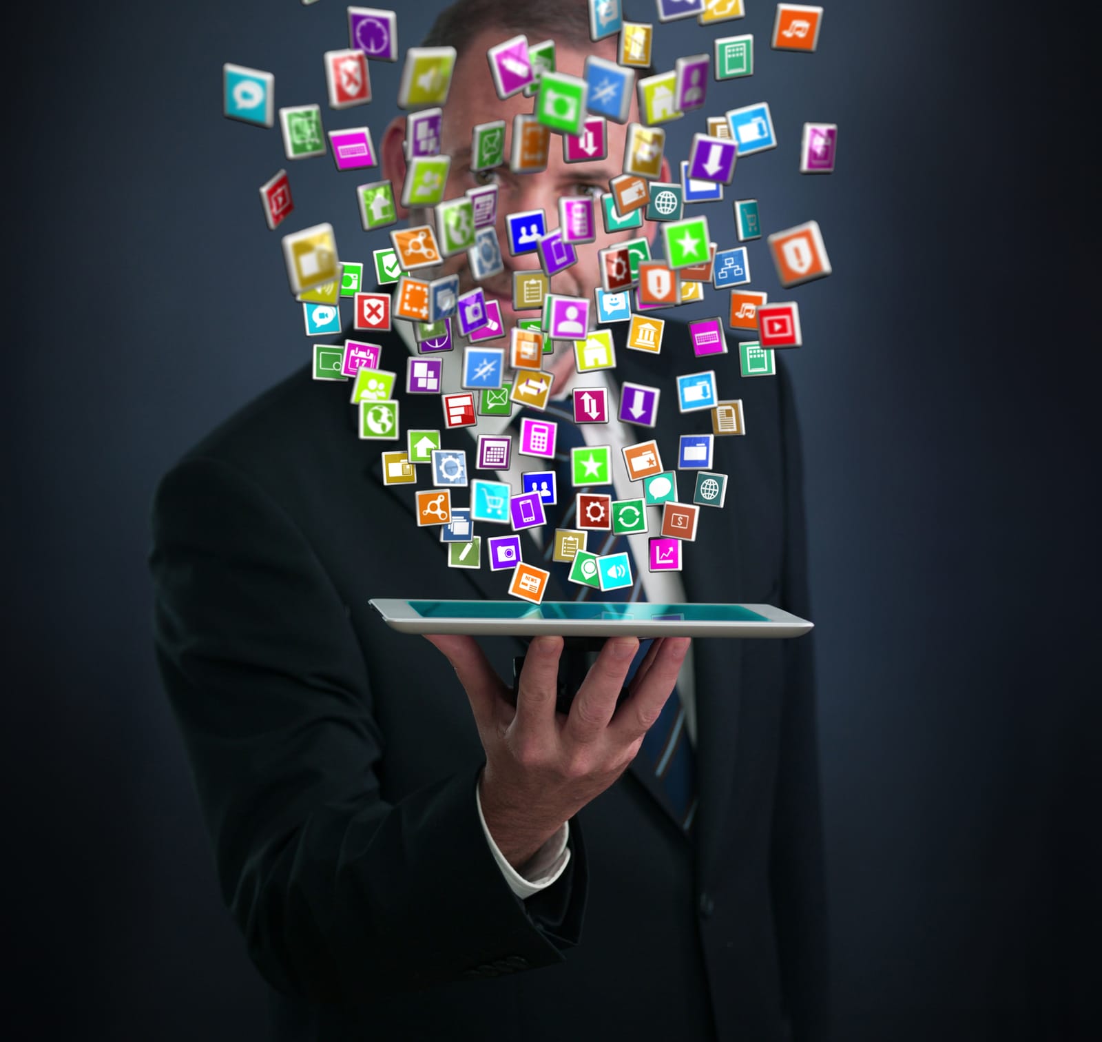 A businessman in a suit holding a tablet, with a cloud of colorful application icons flowing out of the screen, representing the digital ecosystem.