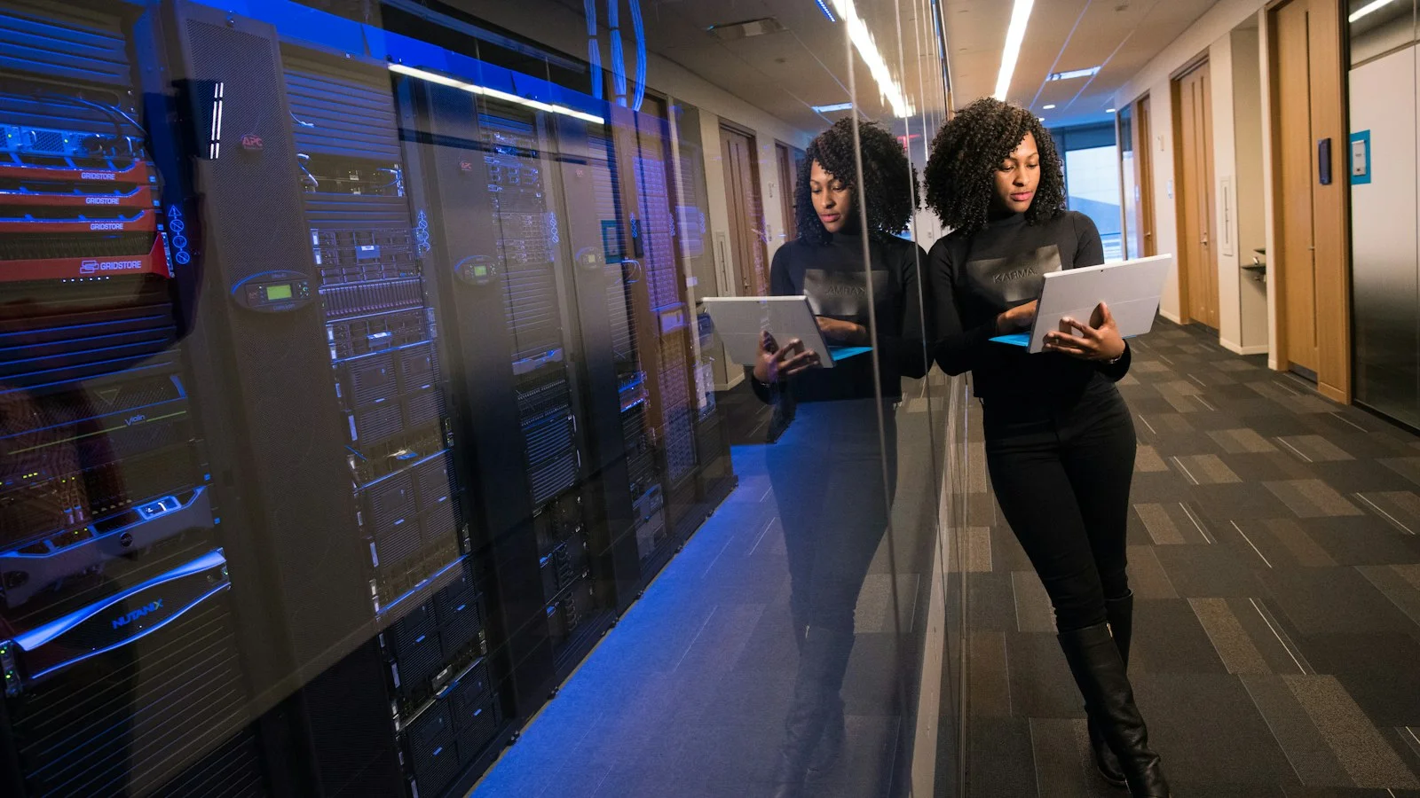 Network Engineer Inspecting Enterprise Cisco Switch Racks and Fiber Patch Panels in Modern Datacenter
